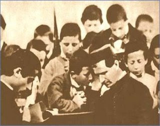 St. John Bosco hearing confessions of his boys.